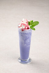 Portion of sweet blueberry milkshake with whipped cream