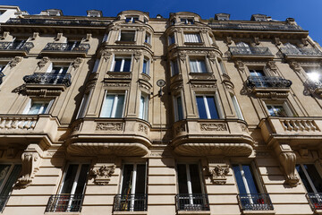 Exterior architecture of Traditional French house with typical balconies and windows in Paris. France.