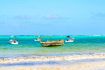 Fototapeta premium Traditional wooden fishing boat dhow and other boats at Zanzibar island, Tanzania