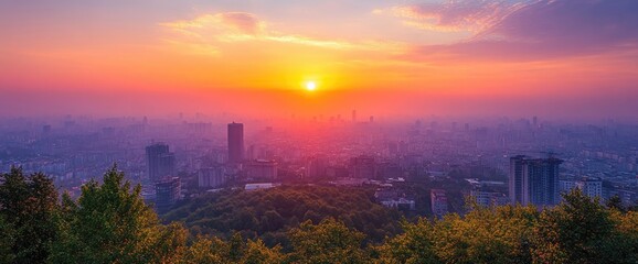 Fototapeta premium Cityscape view from wooded overlook during a colorful sunset with rising structures in distance