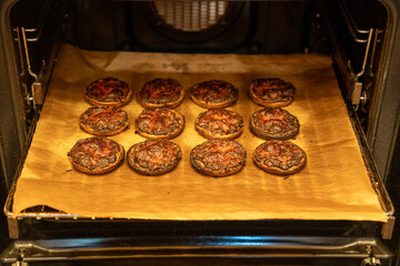 burnt little round pizzas lying on the oven tray
