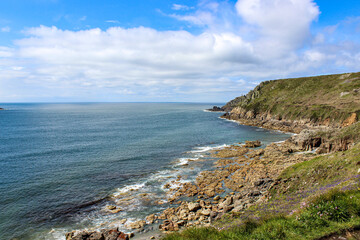 A hillside with a house and a lighthouse on top in England