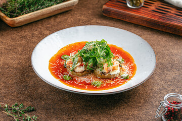 Portion of grilled aubergine appetizer with shimp and sauce