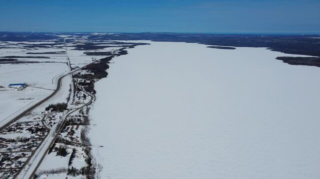 Aerial view of frozen, snow‑covered Lake Matapedia in the Matapedia Valley, fully whitened by the winter season in Quebec, Canada