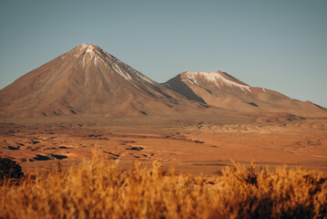 Obraz premium GeView of Licancabur Volcano - Atacama Desert in Chile - dry vegetation and blue sky, desert photos, mobile background, Chile backgroundnerated image