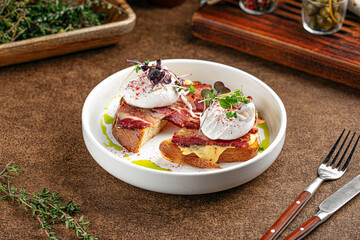 Portion of breakfast with bacon and poached egg on toast
