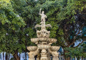 Obraz premium A baroque fountain in the shape of a pyramid, topped by the goddess of abundance riding an eagle while fighting the hydra