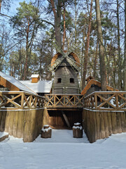 Tiny dwarf village hidden in the forest. Snow covered elf houses. Whimsical travel place. Windmill at the thematic park.