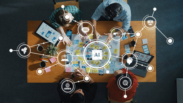 A top-down view of a collaborative team working on AI technology development with digital tools on a wooden table, showcasing creativity and innovation in professional settings. Amity