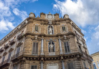 Fototapeta premium Corner of an old historical brown stone building with statues and windows on the side