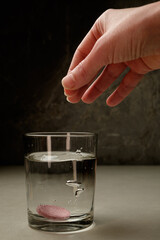 Dropping a tablet into clear water for a fizzy reaction at home
