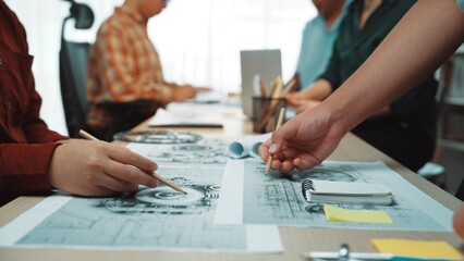 A dynamic scene in a design studio shows a diverse team engaged in sketching and collaboration, showcasing creativity and teamwork in a modern workspace setting. SACTR