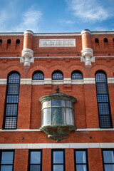An old New England brick building with a Christmas tree in the window