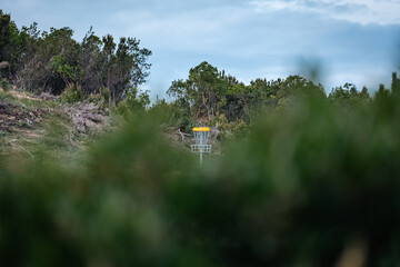 yellow disc golf basket in the mountains