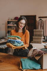 Female volunteer holding clothes collected for charity or converting discarded materials