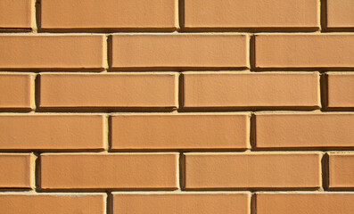 Beige brick wall, texture, background. The wall of a building, made of sand-colored bricks. Brick surface, backdrop. Yellow bricks in decorative construction. Even brickwork in exterior or interior