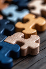 Teamwork and diversity represented through interlocking wooden jigsaw puzzle pieces in a collaborative setting