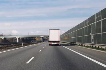 Truck on highway. Fast cargo transport. Logistics in motion. Road freight delivery. Long distance drive. Modern road system. Clear weather. Efficient supply chain. Smooth traffic flow.