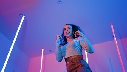 Low angle camera of hispanic dancer looking at camera and dancing to city pop music. Professional...