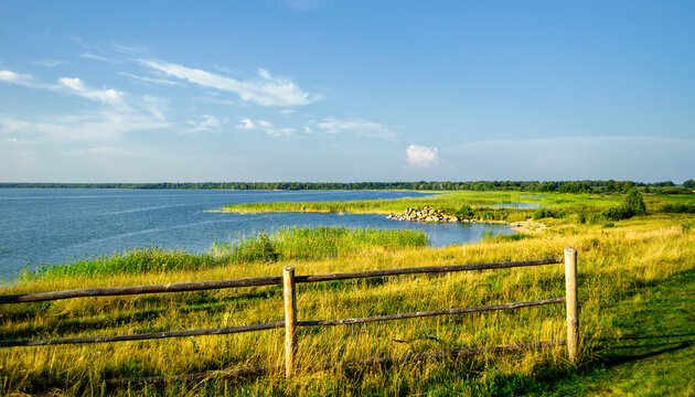 Summer sunset rural landscape - wooden fence along the curved coast of Big Allaki Lake in Southern Urals, Russia. Soft filter applied - Powered by Adobe