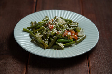 Tzimmes with green beans and tomatoes sprinkled with sesame seeds Jewish dish