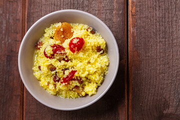Couscous with dogwood nuts and raisins in a plate on the table