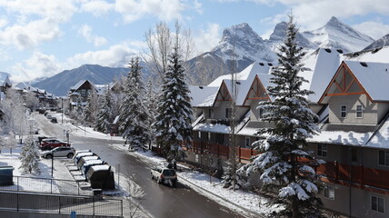 Fototapeta premium Snowy Street Scene in Canmore, Alberta, with Mountain Peaks in the Background 
