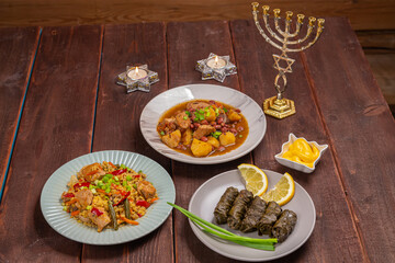 Menorah lighted candles in candlesticks with the Star of David at the set table