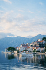Fototapeta premium Tourist boat is moored to the coast of Perast against the backdrop of mountains. Montenegro