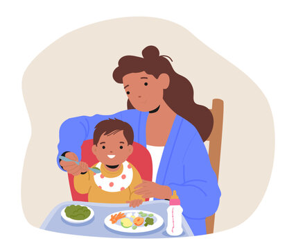 Mother helping toddler son to eat porridge, fruits and vegetables healthy nutrition from spoon