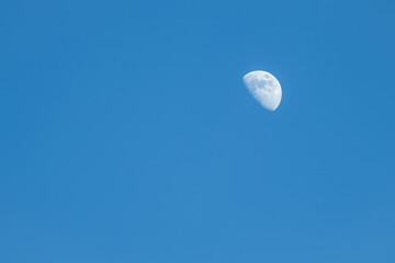 A photo of daytime Moon on a blue sky in a waxing phase (waxing gibbous) taken in Northern Hemisphere.