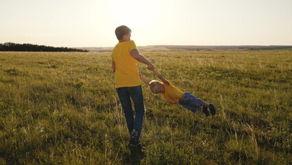 boys are spinning on a green field, happy children are playing in nature, childhood friends, funny...