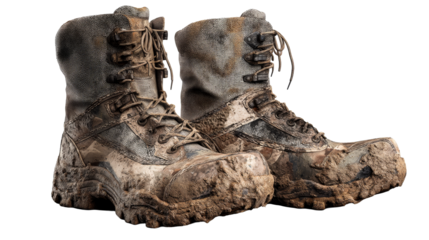 Worn and muddy hiking boots on transparent background