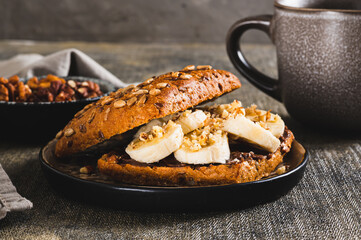 Close up of toast rye bread with chocolate and banana on a plate on the table
