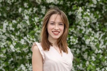 Fototapeta premium Young beautiful girl posing in a blooming garden