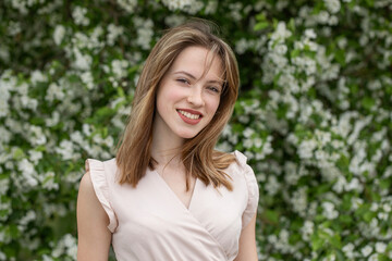 Fototapeta premium Young beautiful girl posing in a blooming garden