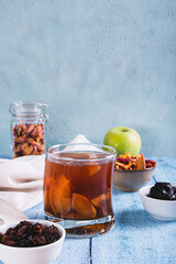 Traditional drink made from prunes, raisins and apples uzvar in a glass on the table vertical view