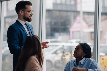 Businessman leading a meeting with his diverse team in modern office