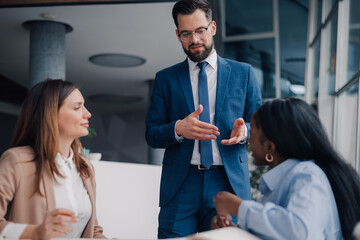 Businessman leading meeting with diverse team in modern office