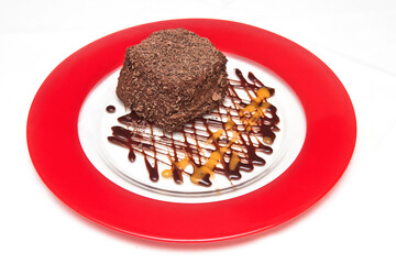 Chocolate cake topped with chocolate chips and mango and chocolate syrup, chocolate flake cake, dessert