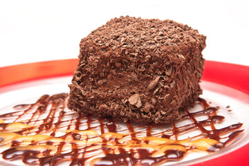 Chocolate cake topped with chocolate chips and mango and chocolate syrup, chocolate flake cake, dessert