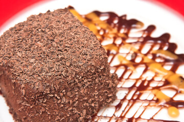 Chocolate cake topped with chocolate chips and mango and chocolate syrup, chocolate flake cake, dessert