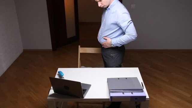 A man touches his stomach and notices that he has gained extra weight