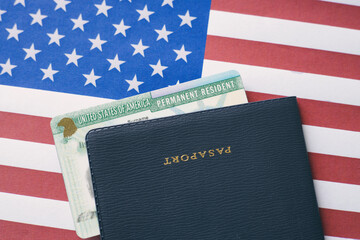 Passport and permanent resident (green) card on US flag. Immigration concept	