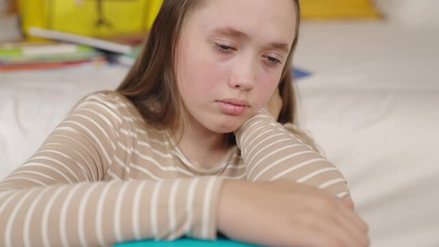 teenager girl with book in her hands is sitting on floor sadness, kiddie anger irritation, child's emotional fear of loneliness, stressful pain in adolescence, school failures and student experiences.