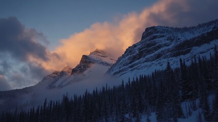 Obraz premium Snowy mountains with clouds and evergreens at dusk creating a serene and majestic landscape view