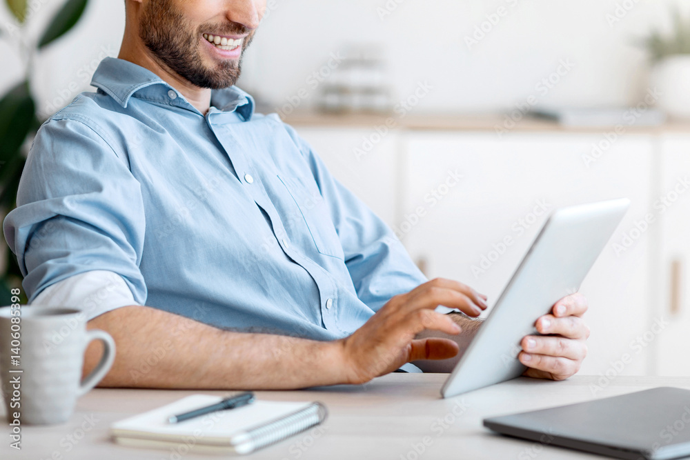Poster handsome young businessman using digital tablet at workplace in office, browsing new application or 