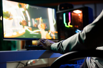 Guy playing first person shooter videogame with automatic gun shooting laser bullets at flying robotic foes. Close up of gamer competing in PvP online multiplayer game tourney against opponents