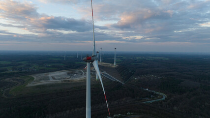 Wind turbine, renewable sustainable energy in Germany. Sunset aerial view. Green electricity from the wind. Blades, rotor.