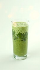 Fresh green smoothie in glass showcasing layers of fruits and greens on white backdrop with soft lens flares